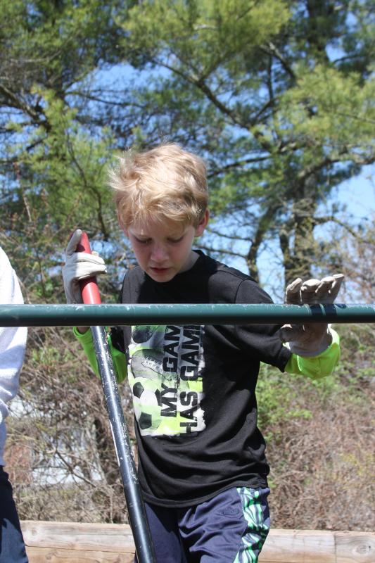 Fifth grade student Jackson Veugen digs in to help level the ground at Minot Forest's new playground. BY MATTHEW BERNAT